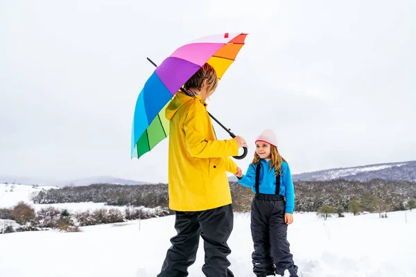 Жінка Дочка Щасливо Тримаючись Руки Несе Різнокольорову Парасольку Снігу Горі — стокове фото