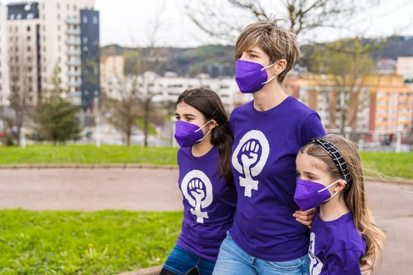 3月8日 母女们走在大街上 身穿带有职业女性标志的紫色T恤衫 头戴口罩 以应对这场大流行病 — 图库照片