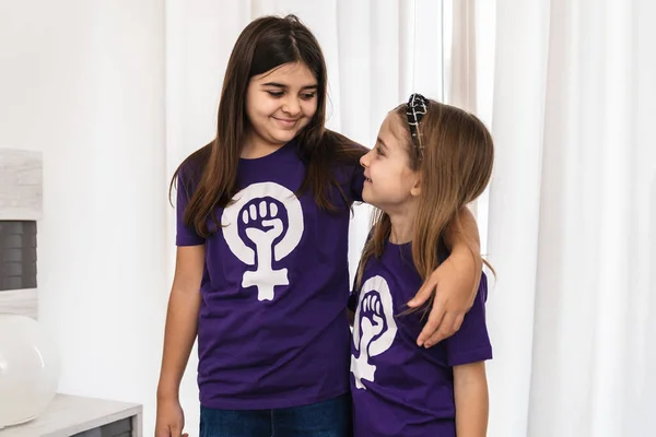 Mor tişörtler içinde uluslararası feminist çalışan kadınlar günü sembolü olan kızlar odalarında toplanıyor.