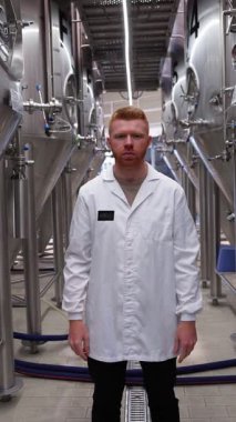 Beyaz önlüklü, kızıl saçlı profesyonel bira üreticisi kollarını çapraz yapıp gülümsedi. Etrafı çelik fermantasyon tanklarıyla çevriliydi.