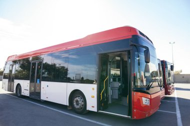 Modern şehir otobüsleri bir depo tesisine park edilmiş, toplu taşıma hizmetine hazır. Kentsel taşınma ve sürdürülebilirlik kavramı