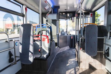 Şehir içi otobüslerde sıra sıra boş koltuklar, bir sürücü kabini ve tırabzanlar, kentsel taşımayı sembolize ediyor.