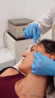 Estetik doktor, biyostimülasyon ve yaşlanma karşıtı cilt gençleştirme için kadın hastanın yüzüne deri doldurucu enjekte ediyor.