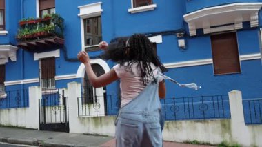 Genç Afro Latin çift ağır çekimde salsa yaparken eğleniyor. Neşeli erkek ve kadın romantik ve mutlu bir anın tadını çıkarıyorlar.