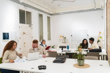 Profesyoneller ortak bir çalışma alanında çalışıyorlar, iş stratejilerini tartışıyorlar ve teknolojiyi takım çalışması için kullanıyorlar.