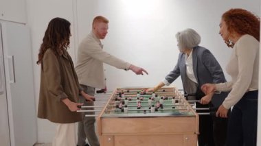 Çok nesilli ve çeşitli meslekdaşlar langırt oynarken eğleniyorlar. Mutlu iş arkadaşları dinlenme ve takım oluşturma etkinliğinin tadını çıkarıyorlar.