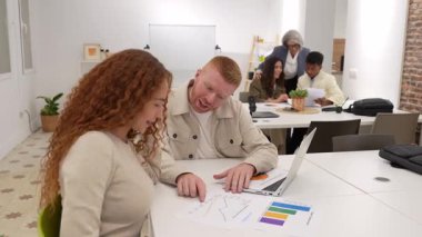 Modern ortak bir ofiste iş raporlarını ve çizelgeleri analiz eden çok ırklı iş arkadaşları. Bir grup profesyonel beyin fırtınası yapıyor.