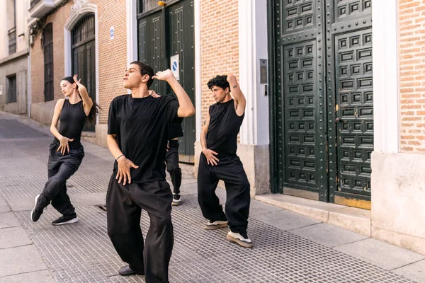 Şehirdeki bir sokakta senkronize hareket eden çeşitli genç dansçılar, şehir dansı yoluyla enerji ve tutku ifade ediyorlar.