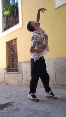Şık bir genç adam bir sokak arasında modern bir sokak dansı gösterisi yapıyor. Akıcı ve enerjik hareketleri yeteneğini gösteriyor.