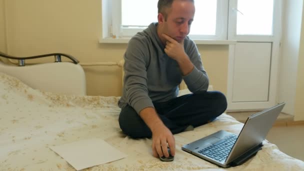 Muž, zaměřený na práce nebo sociální média na jeho laptopu — Stock video