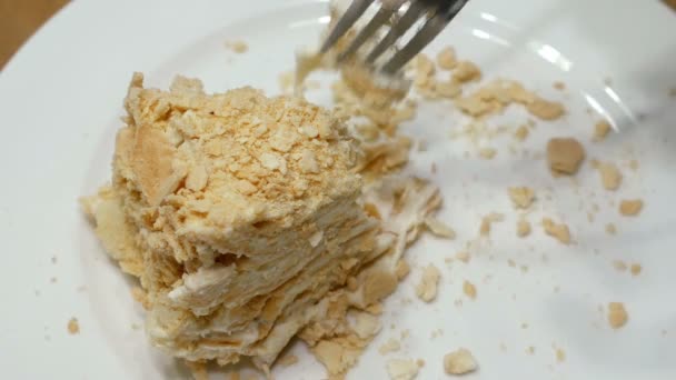 Taart wordt gesneden met vork op witte plaat en opgegeten — Stockvideo