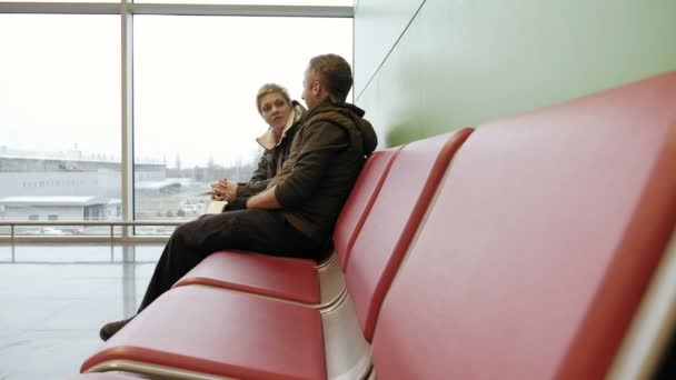 Casal esperando no terminal do aeroporto com bilhetes — Vídeo de Stock