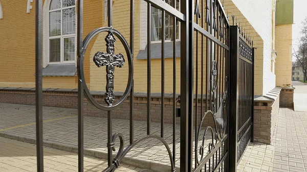 Metal fence and gate with cross of the churchyard — Stock Photo, Image
