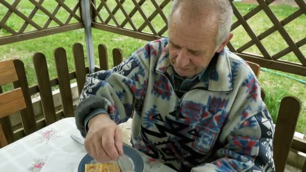Ανώτερος ηλικιωμένοι άνθρωπος τρώει και πίνει τσάι στο αίθριο — Αρχείο Βίντεο