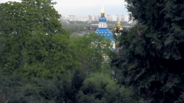 White blue and gold orthodox church in trees — Stock Video