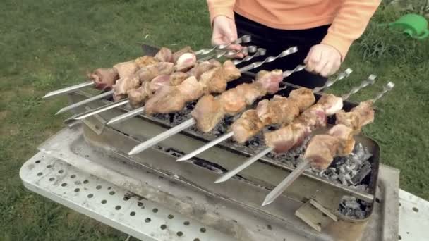 Menina cozinha espetos de churrasco com carne no braseiro — Vídeo de Stock