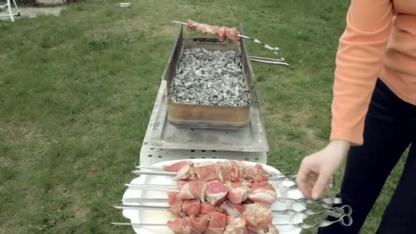 Chica pone pinchos de barbacoa con carne en brasero — Vídeo de stock