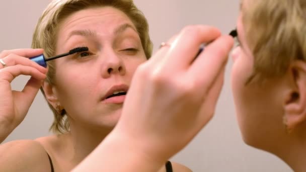 Bella donna che applica trucco mascara ciglia — Video Stock