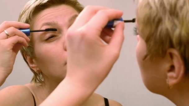 Hezká žena použití make-up řasenka řasy — Stock video