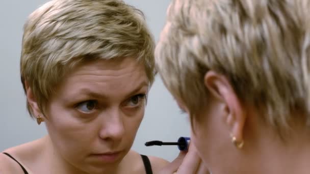 Pretty woman applying eyelashes mascara makeup — Stock Video