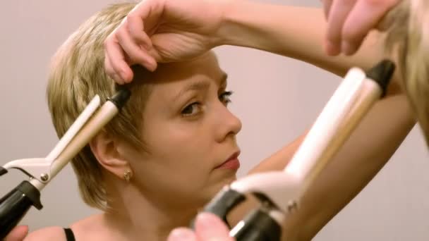 Mujer de pelo corto riza su cabello con rizador — Vídeo de stock