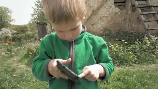 Niño juega con el teléfono inteligente o tableta PC — Vídeos de Stock