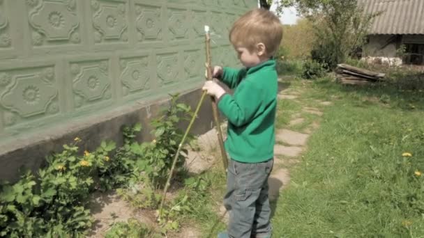 Šťastný chlapec hraje s lukem skoků a úsměvy — Stock video