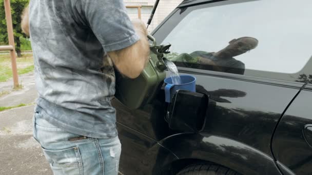 Man brandstoffen auto van jerry can benzine gas of diesel — Stockvideo