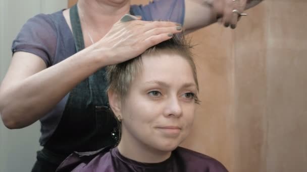 Friseur schneidet Kämme und frisiert Damenhaare — Stockvideo