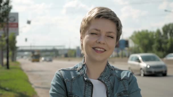 Femme se tient sur le bord de la route de la circulation urbaine — Video