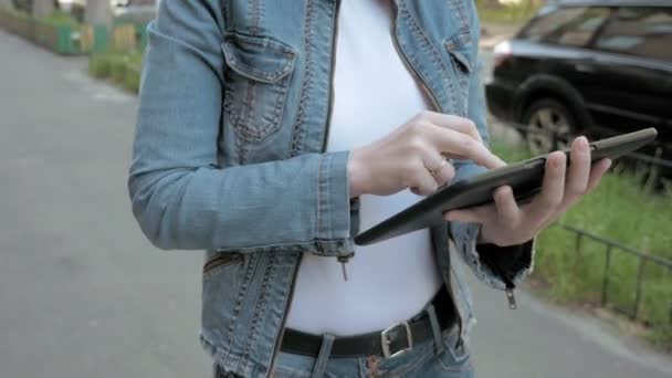 Жінка друкує тексти на планшетному ПК, що йдуть на відкритому повітрі — стокове відео