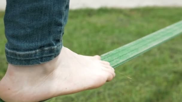 Una persona es equilibrio caminando sobre una cuerda verde — Vídeo de stock