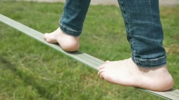 Una persona es equilibrio caminando sobre una cuerda verde — Vídeos de Stock