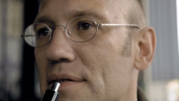 Чоловік видихає електронну сигарету дим з ніздрів — стокове відео
