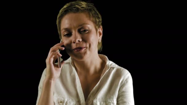 Krátké vlasy blond žena rozhovory po telefonu ve tmě — Stock video