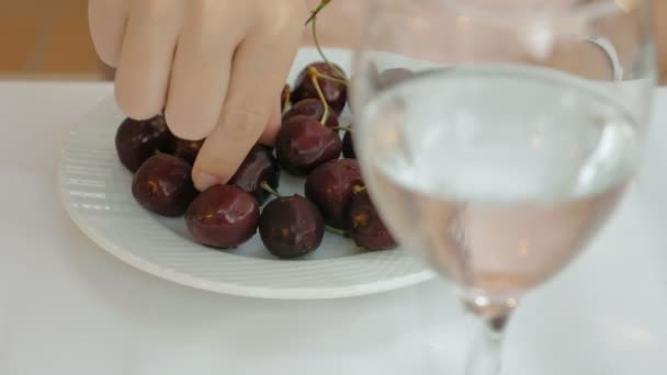 Sweet cherry se sklenicí vody v popředí — Stock video