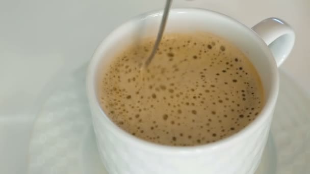 Una persona está revolviendo café caliente con una espuma — Vídeos de Stock