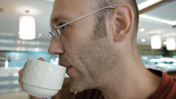 Man enjoying his morning coffee in a public place — Stock Video