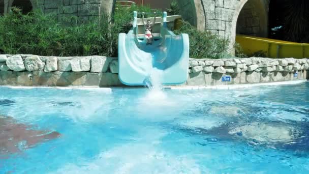 Una mujer adulta está en tobogán de agua en el parque acuático — Vídeos de Stock