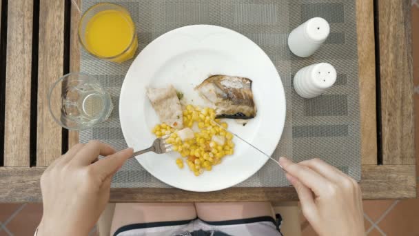 Lady is met behulp van gebruiksvoorwerpen te snijden maaltijd in kleine hapjes — Stockvideo