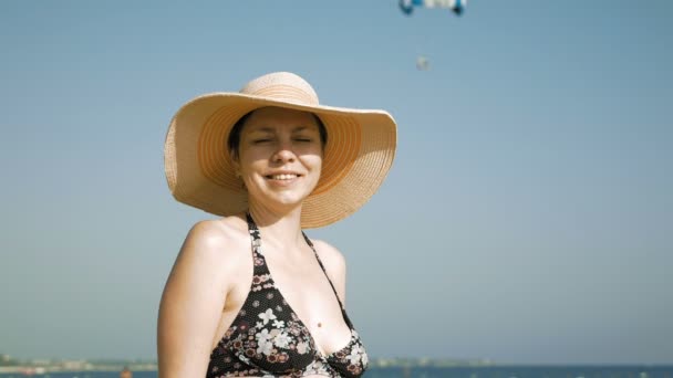 Kvinna som står på stranden med hennes fancy hatt — Stockvideo