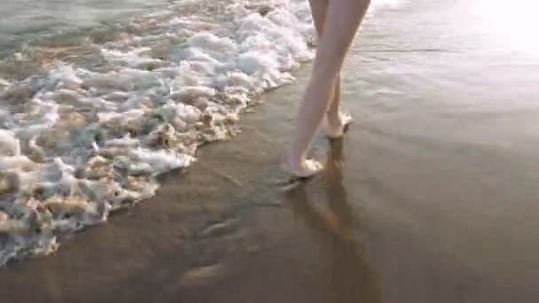 Caminando junto a las olas en la playa — Vídeo de stock