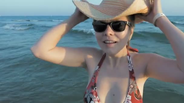 En kvinna i solglasögon att sätta på hennes fedora hatt — Stockvideo