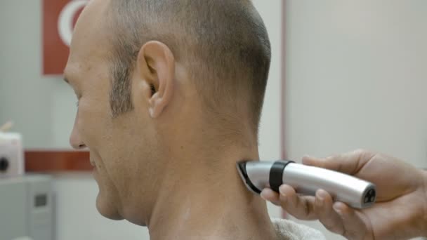 Barber está afeitando el cuello de sus clientes con el esquilador — Vídeos de Stock