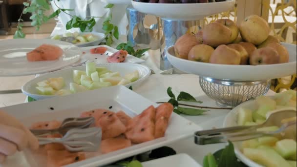 Жінка бере деякі фрукти від шведського столу — стокове відео