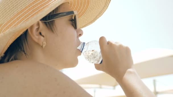 口渴的女性是在海滩喝水 — 图库视频影像