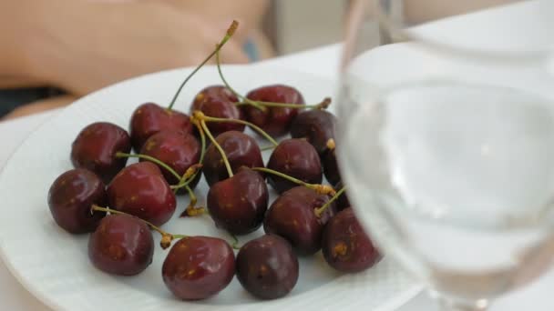 Cerejas doces maduras vermelhas brilhantes em um prato branco — Vídeo de Stock