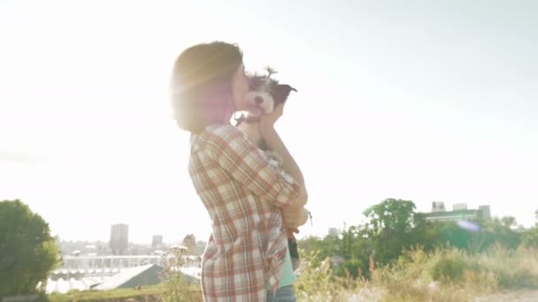 バックライト夕日と手で女性保持犬 — ストック動画