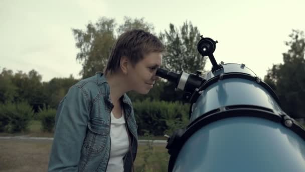 Mujer mirando a la luna a través del telescopio — Vídeo de stock