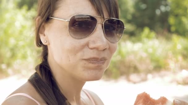 Смайлик жінка їсть послугами кавун на відкритому повітрі на літній — стокове відео